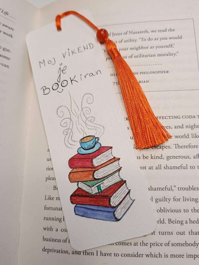 Ručno oslikani označivač stranica (bookmark) s motivom šalice čaja na knjigama i tasselom, dimenzije 15x5, medij akvarel na 300 g/m² papiru. Idealno za ljubitelje knjiga.