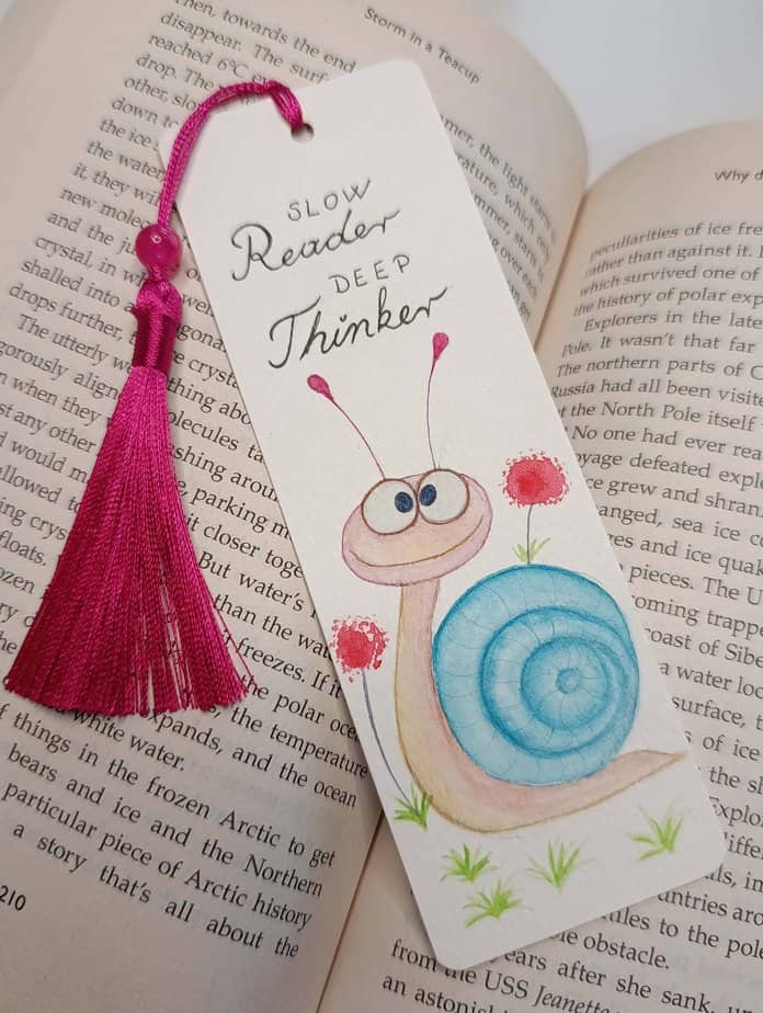 Ručno oslikani označivač stranica (bookmark) s motivom puža i tasselom, dimenzije 15x5, medij akvarel na 300 g/m² papiru. Idealno za ljubitelje knjiga.